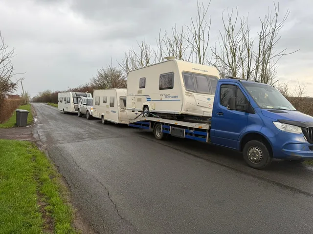 Caravans on transport vehicles beside a road