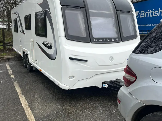 Touring caravan and tow vehicle in a marked parking area